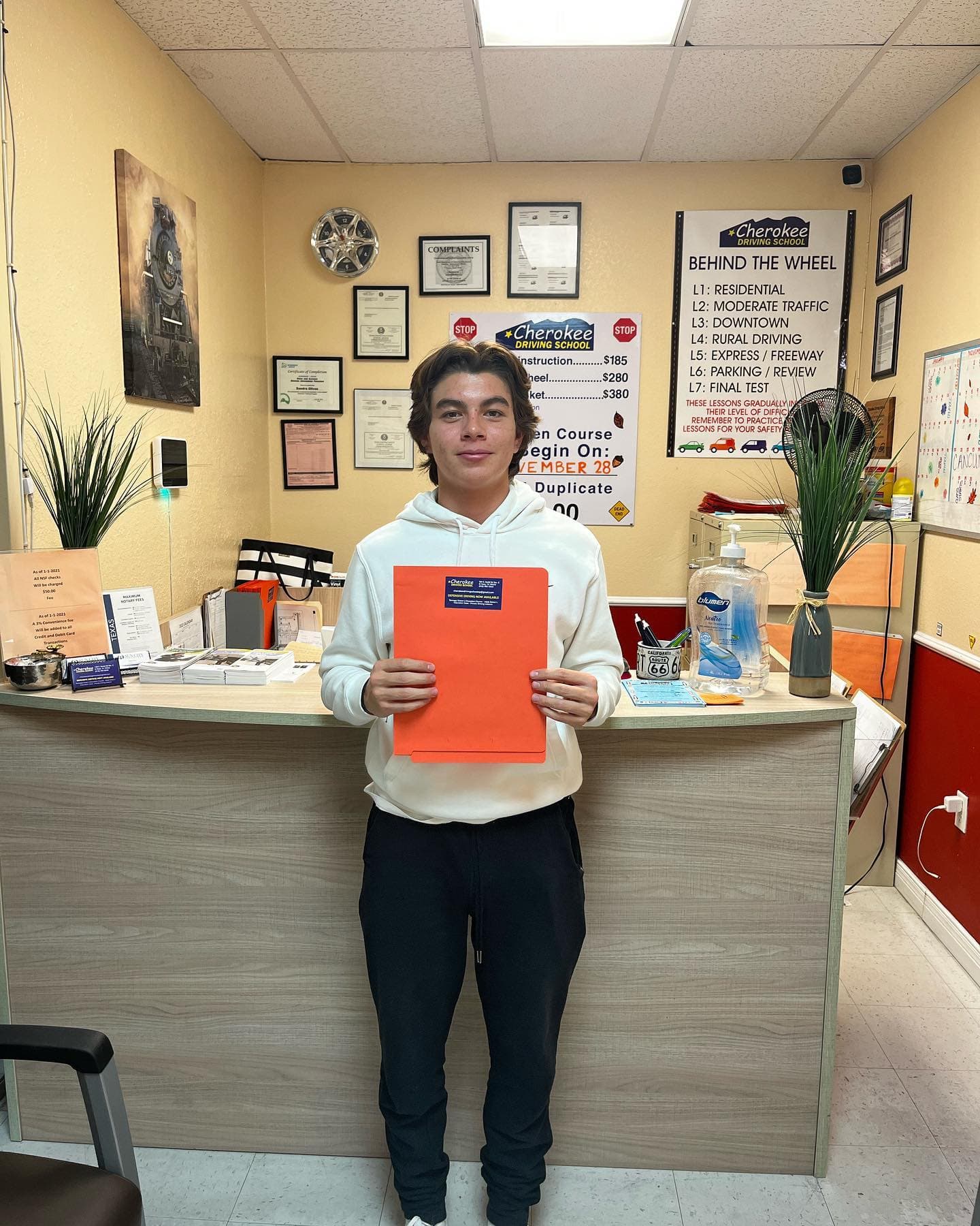 Cherokee Driving School student holding an orange driver education folder